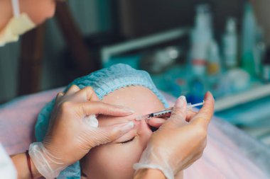 Orta yaş kadın alnında bir klinik cerrahi oda ameliyathane ifade kırışıklıkların kaldırmak için kaşları arasında arka plan Beautify enjeksiyon kaldırma yüz yüz yaşlanma kavramı anti için dolgu veren doktor