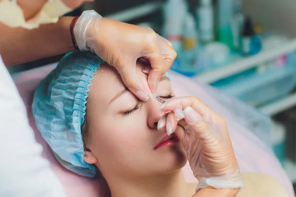 Médico dando cara levantando injeção na mulher de meia idade na testa entre as sobrancelhas para remover rugas de expressão em uma clínica sala de cirurgia fundo O.R embelezar enchimento para rosto conceito anti envelhecimento — Fotografia de Stock