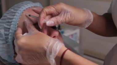 Orta yaş kadın alnında bir klinik cerrahi oda ameliyathane ifade kırışıklıkların kaldırmak için kaşları arasında arka plan Beautify enjeksiyon kaldırma yüz yüz yaşlanma kavramı anti için dolgu veren doktor