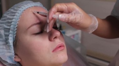 Orta yaş kadın alnında bir klinik cerrahi oda ameliyathane ifade kırışıklıkların kaldırmak için kaşları arasında arka plan Beautify enjeksiyon kaldırma yüz yüz yaşlanma kavramı anti için dolgu veren doktor