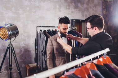 Terzide dikiş dikmek için ölçü alan olgun profesyonel bir terzi. Ölçüm bandı olan adam meşgul. Özel Yapımlı Kumaş Konsepti.