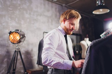 Erkek müşterinin portresi alışveriş merkezinde klasik ceket seçiyor..