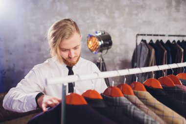 Erkek müşterinin portresi alışveriş merkezinde klasik ceket seçiyor..