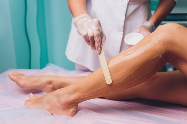 Lazer epilasyon prosedürü önce kişi bir jel uygulanıyor. Uygulama şeker yapıştırın shugaring yordam için.