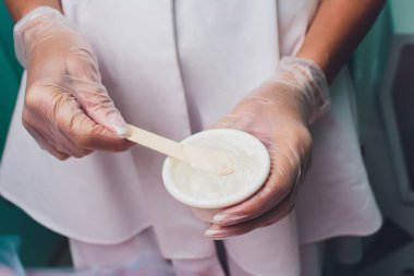 Lazer epilasyon prosedürü önce kişi bir jel uygulanıyor. Uygulama şeker yapıştırın shugaring yordam için.