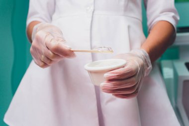 Lazer epilasyon prosedürü önce kişi bir jel uygulanıyor. Uygulama şeker yapıştırın shugaring yordam için.