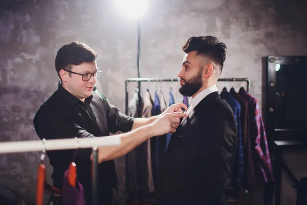 Cliente masculino en el centro comercial probando ropa de negocios, asistente de tienda ayudando al cliente . —  Fotos de Stock