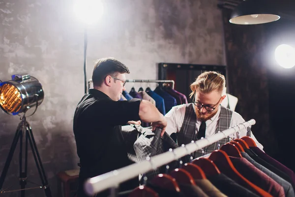 Mužský odběratel v nákupním středisku, který se pokouší o obchodní oděvy, asistent obchodu pomáhající klientovi. — Stock fotografie