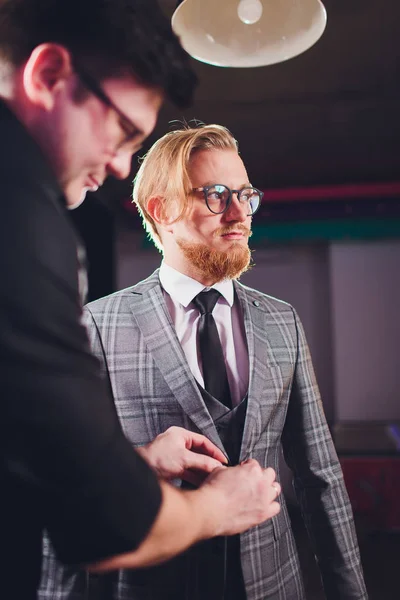 Volwassen professionele tailor het nemen van metingen voor naaipak bij kleermakers winkel. Man met meetlint bezet. Exclusief op maat gemaakte doek concept. — Stockfoto