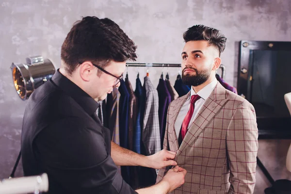 Terzide dikiş dikmek için ölçü alan olgun profesyonel bir terzi. Ölçüm bandı olan adam meşgul. Özel Yapımlı Kumaş Konsepti.