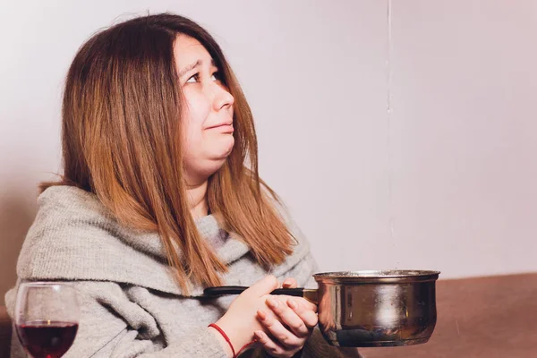 Evde bir kanepede oturan tavan sızıntıları izlerken hayal kırıklığına ev sahibi.