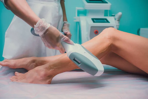 Hair removal cosmetology procedure from a therapist at cosmetic beauty spa clinic. Laser epilation and cosmetology. Teal orange.
