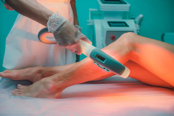 Hair removal cosmetology procedure from a therapist at cosmetic beauty spa clinic. Laser epilation and cosmetology. Teal orange.