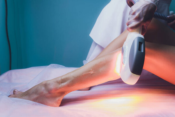 Woman getting laser treatment in medical spa center, permanent hair removal concept.