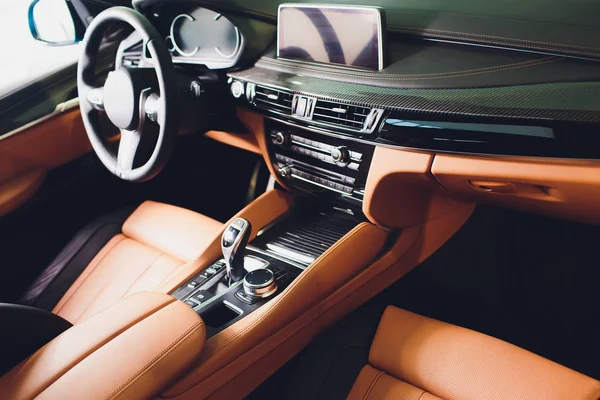Voiture de luxe moderne à l'intérieur. Intérieur de prestige voiture moderne. Sièges confortables en cuir marron. cockpit en cuir perforé orange . — Photo
