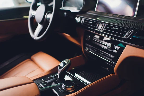 Moderno coche de lujo dentro. Interior de prestigio coche moderno. Cómodos asientos marrones de cuero. Cabina de cuero perforado naranja . — Foto de Stock