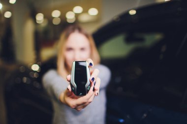 Ekran anahtarı Oto Kiralama Satış Bayi Ajansı. Otomobil satın alma kavramı. kadın elinde modern anahtarlar tutar