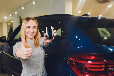 Ekran anahtarı Oto Kiralama Satış Bayi Ajansı. Otomobil satın alma kavramı. kadın elinde modern anahtarlar tutar