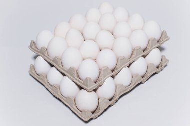 Zararsız bir tavuk beyaz yumurta, beyaz bir arka planda karton ambalaj. 2 paket.