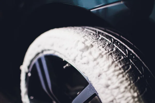 Cuidado del coche o proceso de detalle del coche. Usando esponja negra para lavar el neumático. caucho más negro . — Foto de Stock