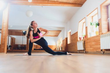 Genç çekici Yogi kadın pratik yoga, Parivrtta Parsvakonasana egzersiz ayakta, dönen yan açı poz, çalışma dışarı, spor giyme, serin kentsel tarzı.