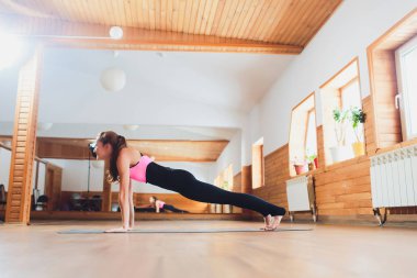 Kadın çatı alanı Kumbhakasana egzersiz yapıyor.