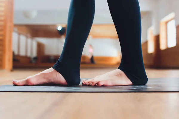 Attraktiv lycklig ung kvinna som tränar inomhus. Sidovy porträtt av vacker modell gör yoga övning på blå matta. Full längd — Stockfoto