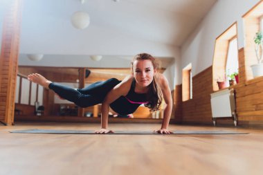 Genç çekici Yogi kadın pratik yoga, Parsva bakasana egzersiz ayakta, yan vinç poz, çalışma dışarı, siyah spor giyim, serin kentsel stil, tam uzunlukta, stüdyo arka plan.