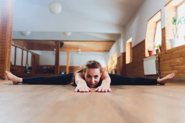 Yoga yaparken siyah giysili kızı. Upavishta Konasana. Kolye üzerinde yazıt.