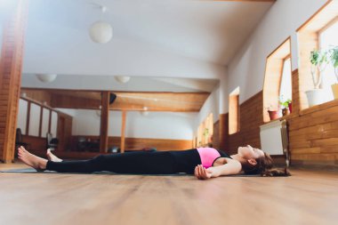 Güzel genç kadın çalışma dışarı yan görünüm portre, Yoga egzersizleri yaptıktan sonra istirahat, Savasana, ceset veya ölü vücut duruş, rahatlatıcı yatıyor. Tam Uzunluk.