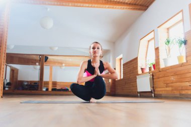 Genç bir kadın dışarıda yoga pozu veriyor..