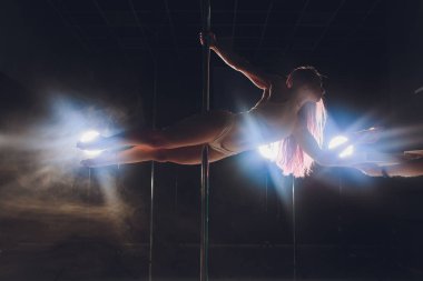 Genç ince kadın Pole ışıklar ve duman ile karanlık iç dans. Pizza yeme