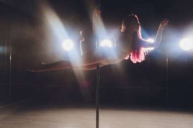 Işık ve duman ile karanlık iç genç ince kadın pole dans.