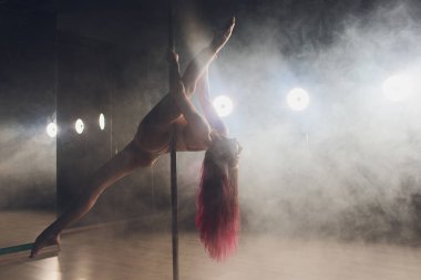 Işık ve duman ile karanlık iç genç ince kadın pole dans.