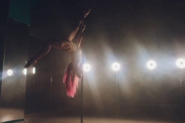 Işık ve duman ile karanlık iç genç ince kadın pole dans.