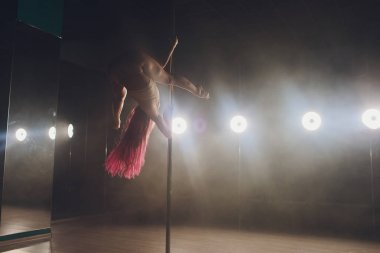 Işık ve duman ile karanlık iç genç ince kadın pole dans.