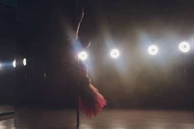 Işık ve duman ile karanlık iç genç ince kadın pole dans.