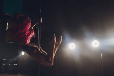 Işık ve duman ile karanlık iç genç ince kadın pole dans.