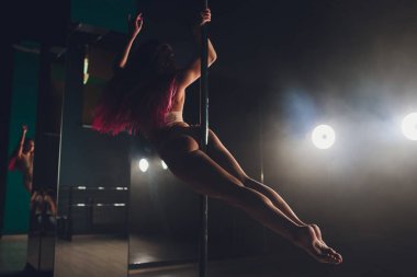 Işık ve duman ile karanlık iç genç ince kadın pole dans.