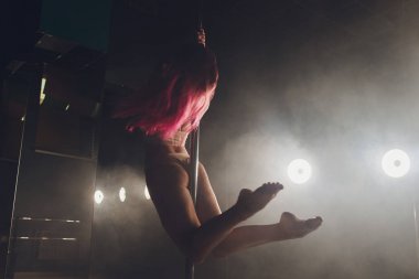 Işık ve duman ile karanlık iç genç ince kadın pole dans.