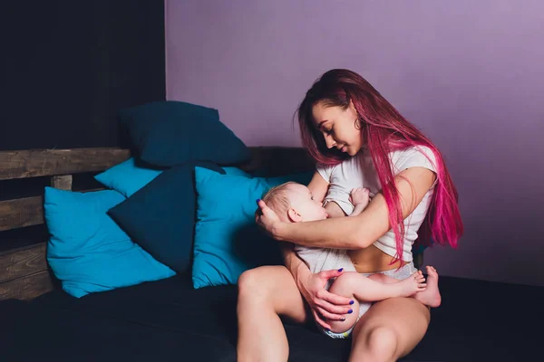 Mother breastfeeding baby in her arms at home. Beautiful mom Red hair breast feeding her newborn child. Baby eating mothers milk. Young woman nursing and feeding baby. Concept of lactation infant. — Stock Photo, Image