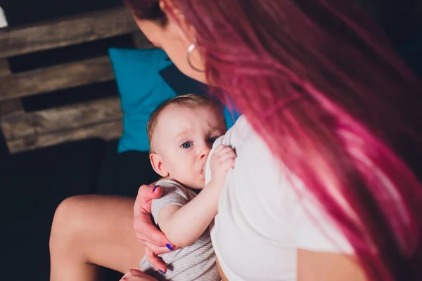 Mother breastfeeding baby in her arms at home. Beautiful mom Red hair breast feeding her newborn child. Young woman nursing and feeding baby. Concept of lactation infant. — Stock Photo, Image