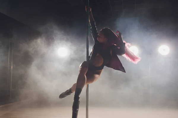 Hermosa bailarina de polo en chaqueta de cuero en el pilón . — Foto de Stock