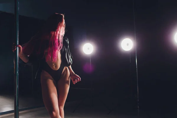Rosso dai capelli pole dance ragazza esercizi e pose sul pilone nel fumo sullo sfondo nero . — Foto Stock