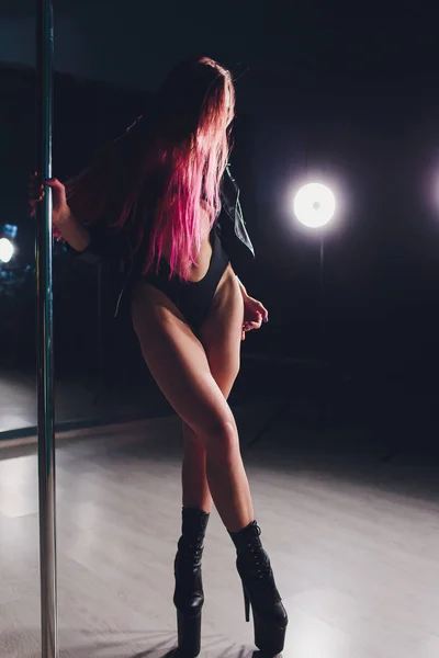 Röd haired pole dance tjejen övningar och poser på pylonen i röken på den svarta bakgrunden. — Stockfoto