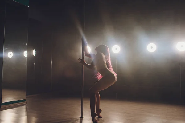 Joven mujer delgada pole bailando en interior oscuro con luces y humo . — Foto de Stock