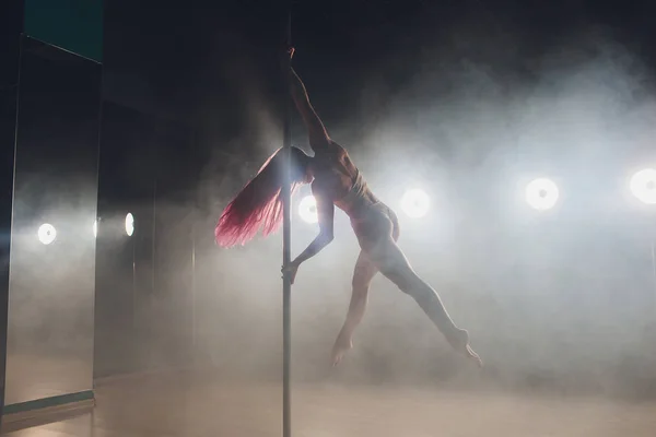 Joven mujer delgada pole bailando en interior oscuro con luces y humo . — Foto de Stock