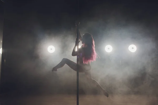 Joven mujer delgada pole bailando en interior oscuro con luces y humo . — Foto de Stock