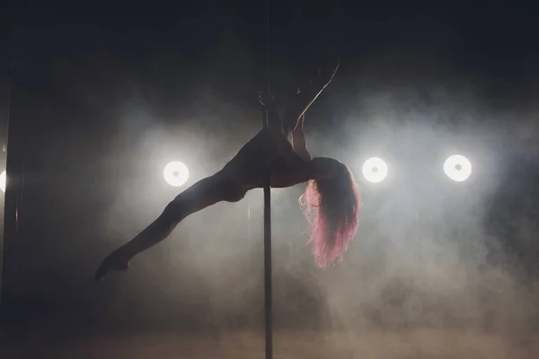 Joven mujer delgada pole bailando en interior oscuro con luces y humo . — Foto de Stock