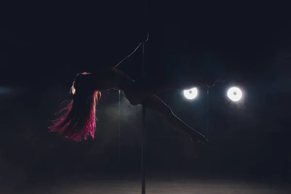 Joven mujer delgada pole bailando en interior oscuro con luces y humo . — Foto de Stock